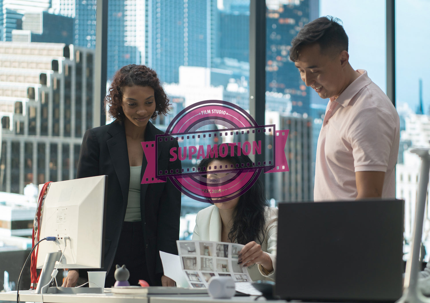 Diverse team of employees brainstorming, gathering around the computer screen