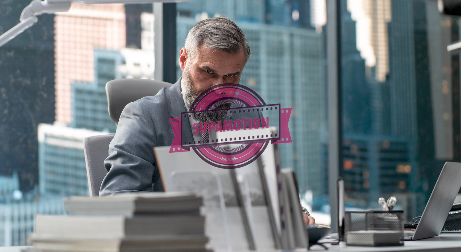 Portrait of 50s adult Caucasian businessman signing documents in his office 