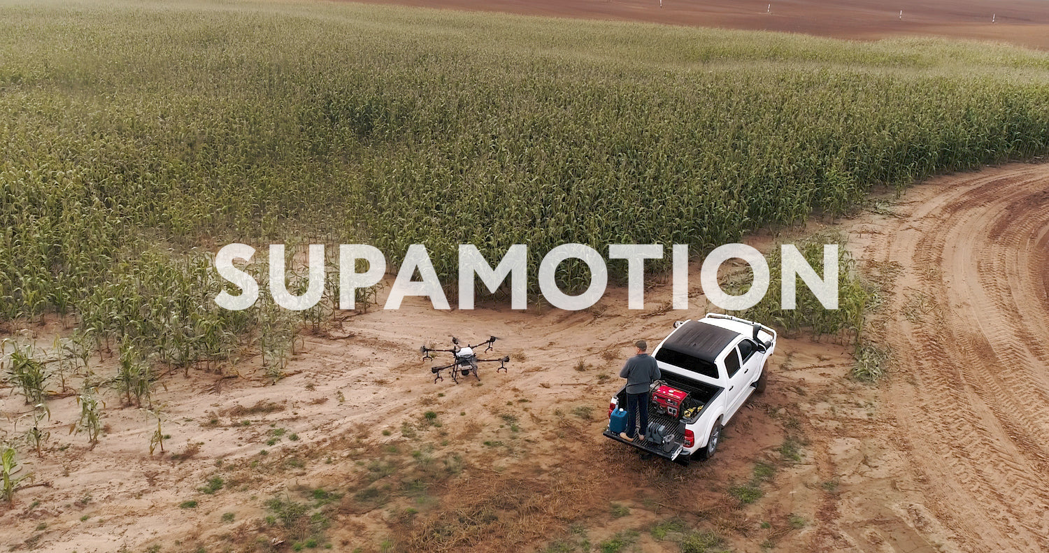 AERIAL Farmer controlling a huge intelligent agriculture drone near corn field