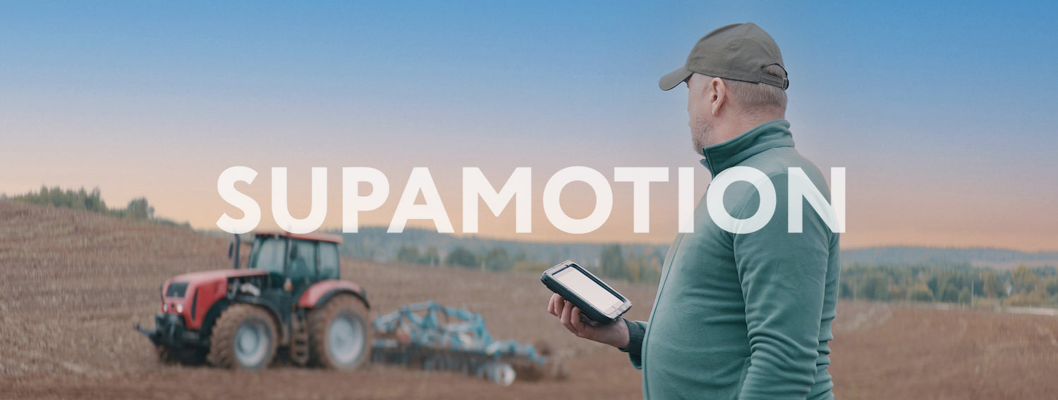 Portrait of 50s Caucasian male farmer using a tablet while standing in the field