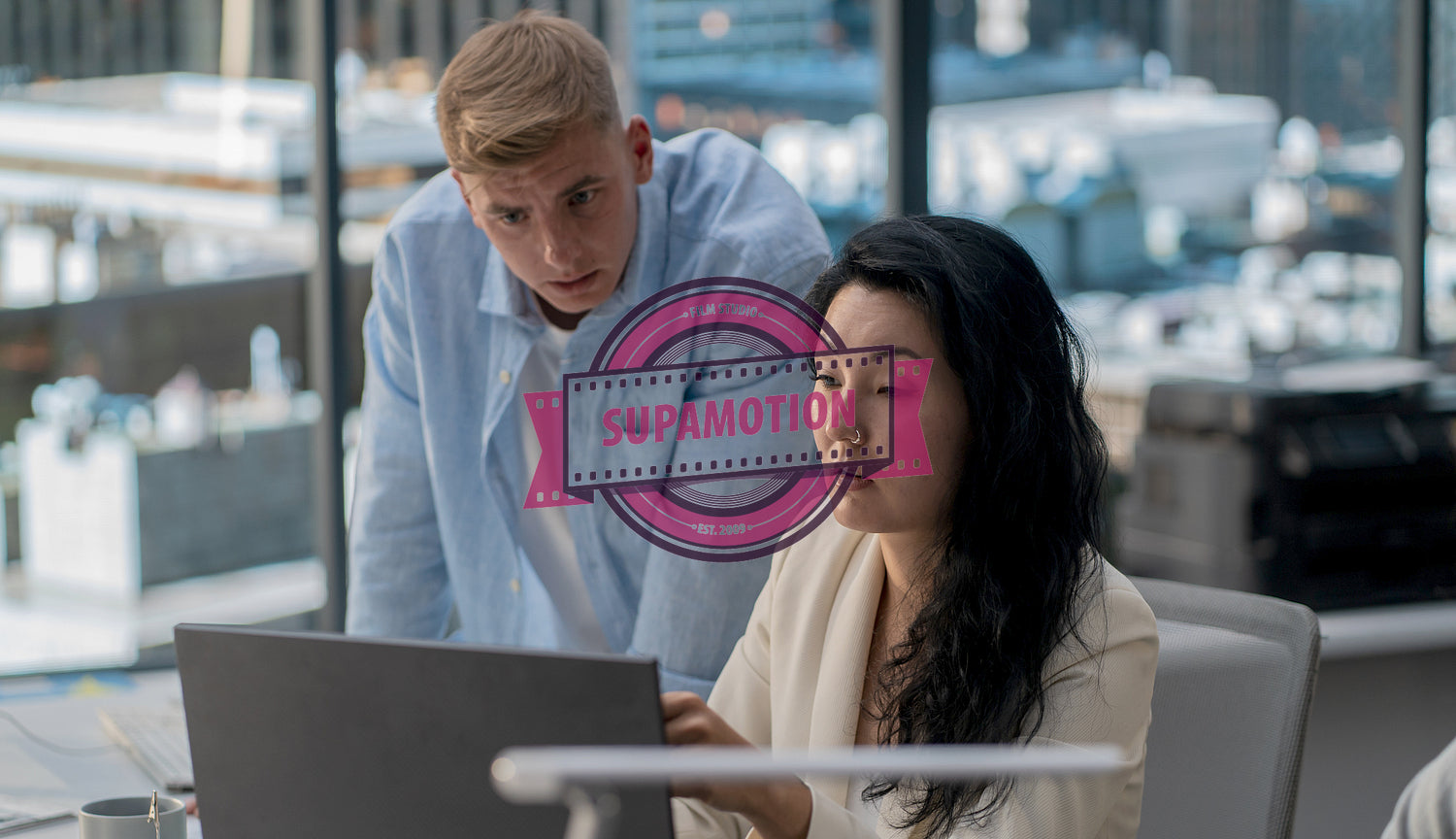 Diverse team of employees brainstorming, gathering around the computer screen