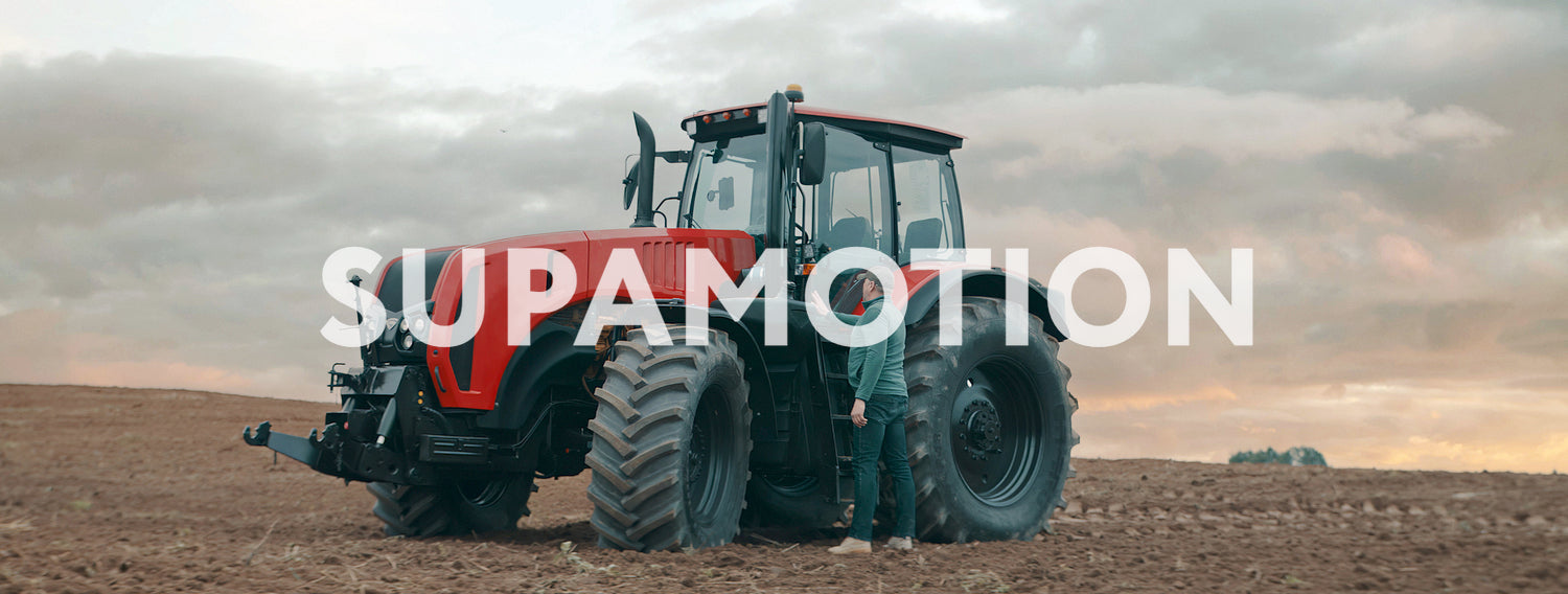 Portrait of 50s farmer walking towards tractor early in the morning in the field