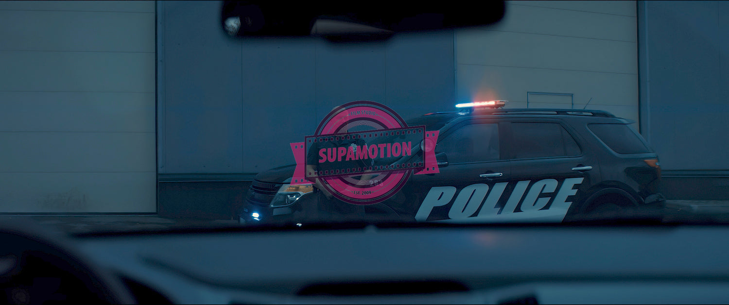 Caucasian male police officer standing guard in the street near police car