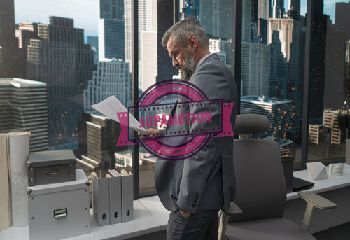 Portrait of 50s adult Caucasian businessman looking through papers near window