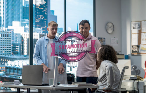 Diverse team of employees brainstorming, gathering around the computer screen