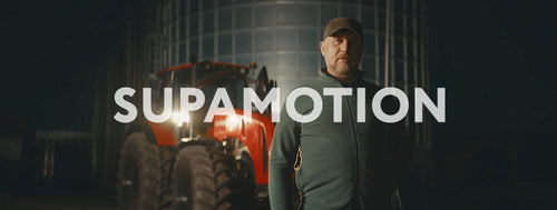 Portrait of 50s farmer posing on his farm near tractor before sunrise