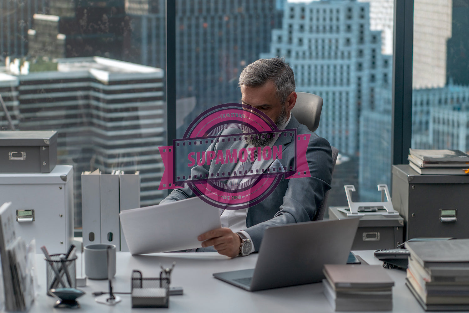 Portrait of 50s adult Caucasian businessman signing documents in his office 