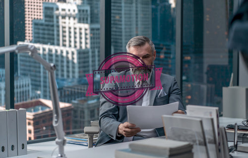 Portrait of 50s adult Caucasian businessman working at his desk in the office