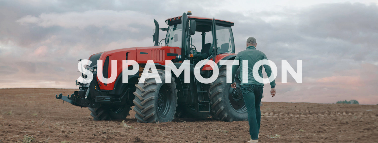 Portrait of 50s farmer walking towards tractor early in the morning in the field