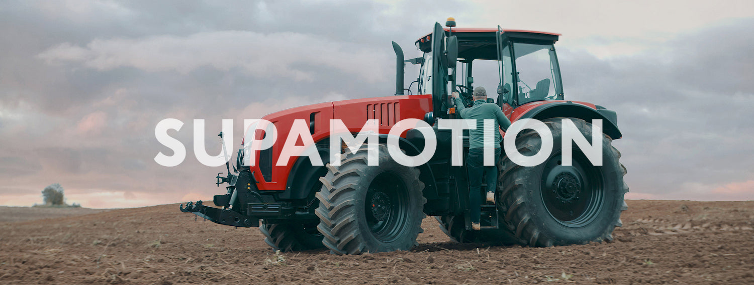 Portrait of 50s farmer walking towards tractor early in the morning in the field