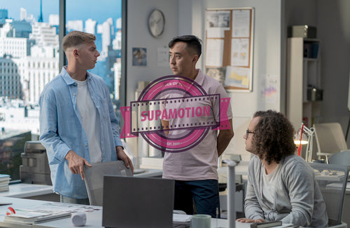 Diverse team of employees brainstorming, gathering around the computer screen