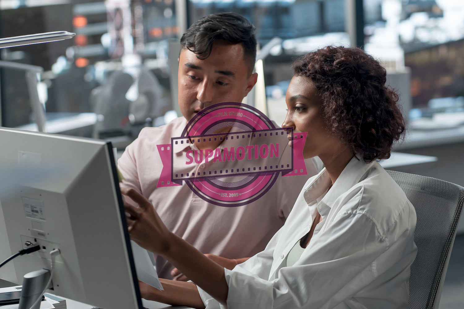 Diverse team of employees brainstorming, gathering around the computer screen