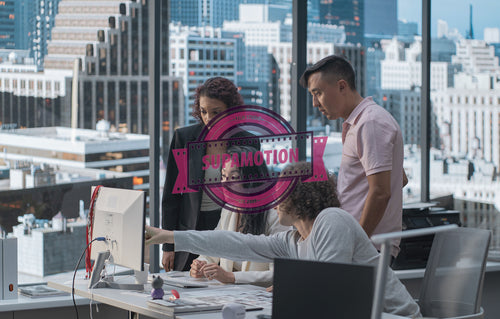 Diverse team of employees brainstorming, gathering around the computer screen