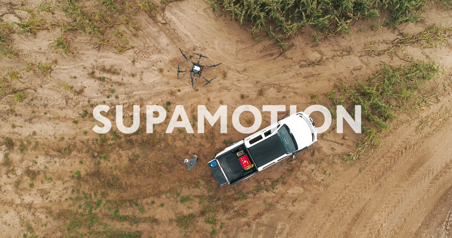 AERIAL Farmer controlling a huge intelligent agriculture drone near corn field