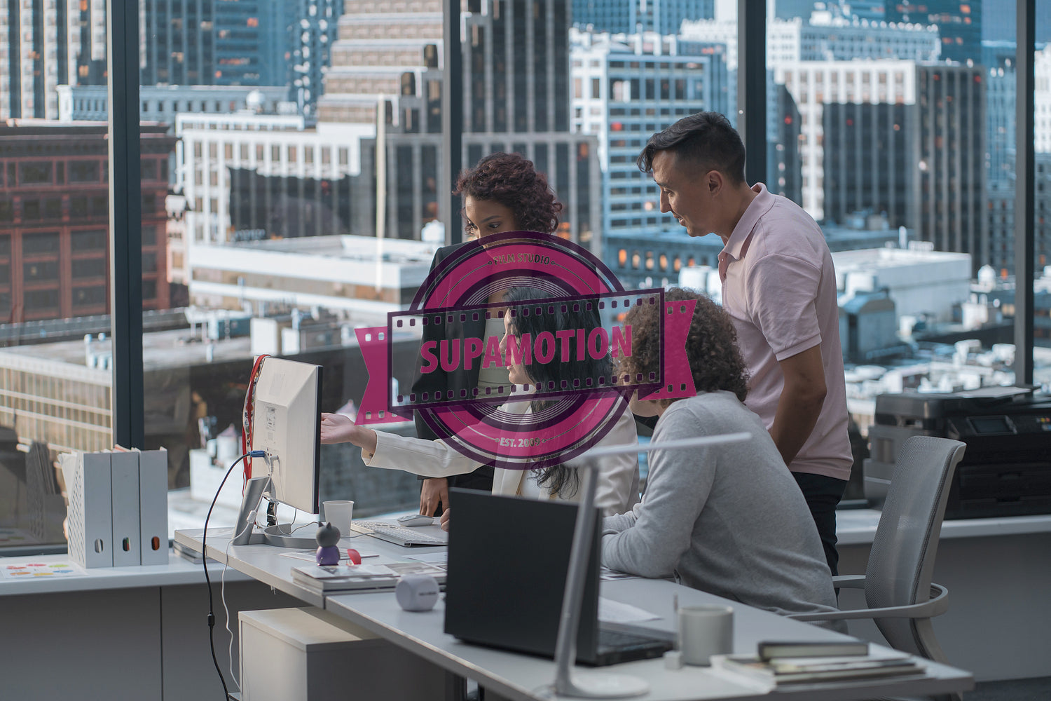 Diverse team of employees brainstorming, gathering around the computer screen