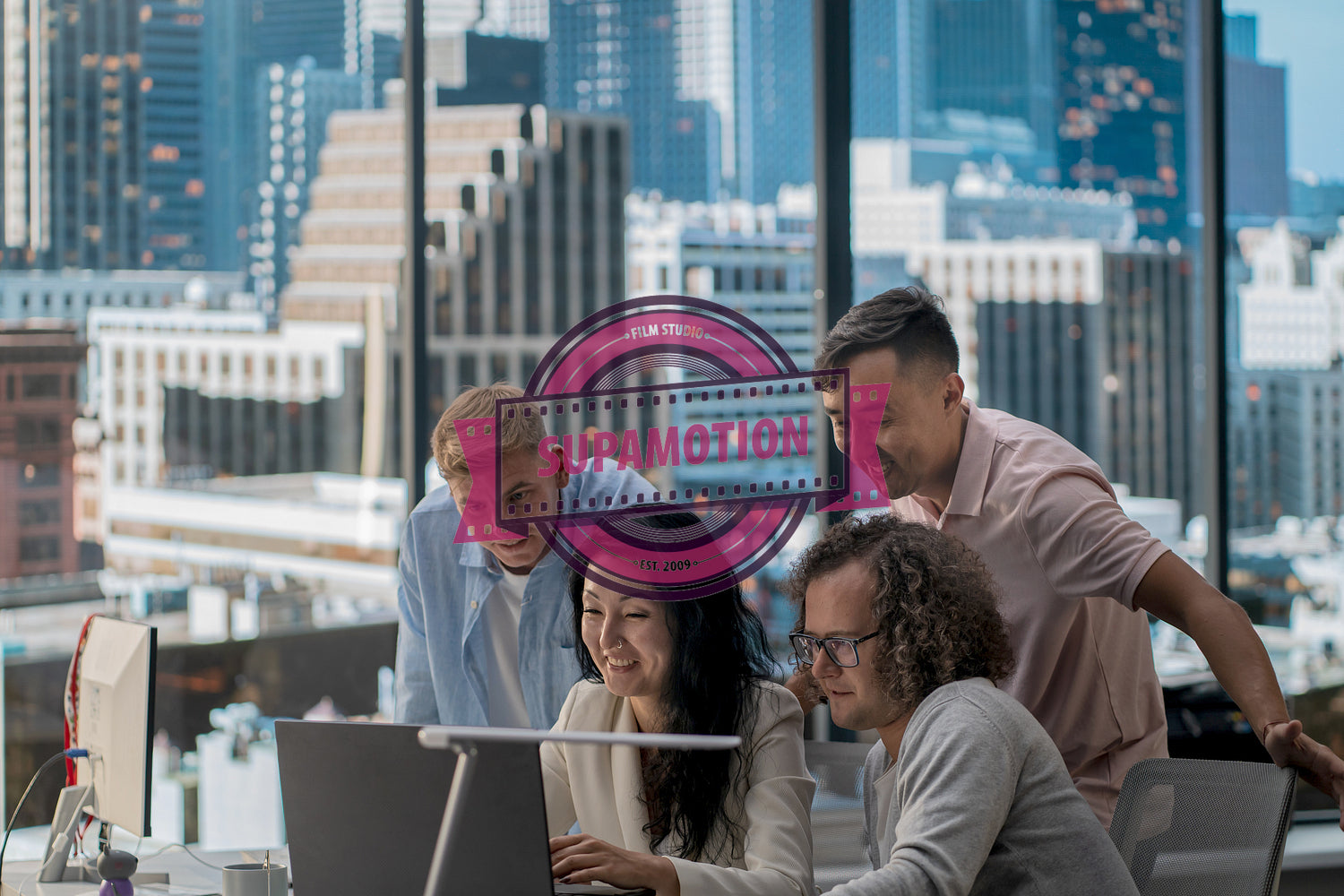 Diverse team of employees brainstorming, gathering around the computer screen