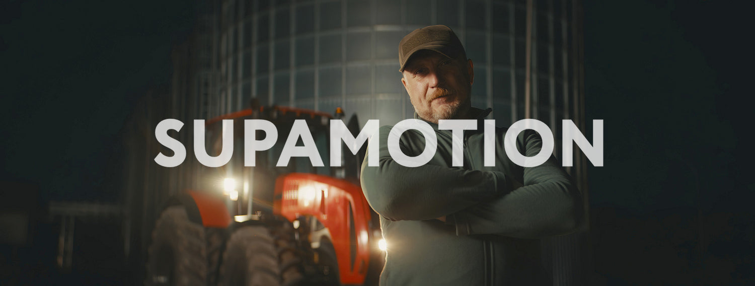 Portrait of 50s farmer posing on his farm near tractor before sunrise