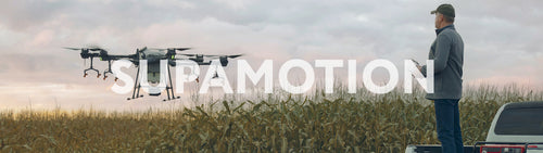 Huge intelligent agriculture drone with spray nozzles taking off near corn field