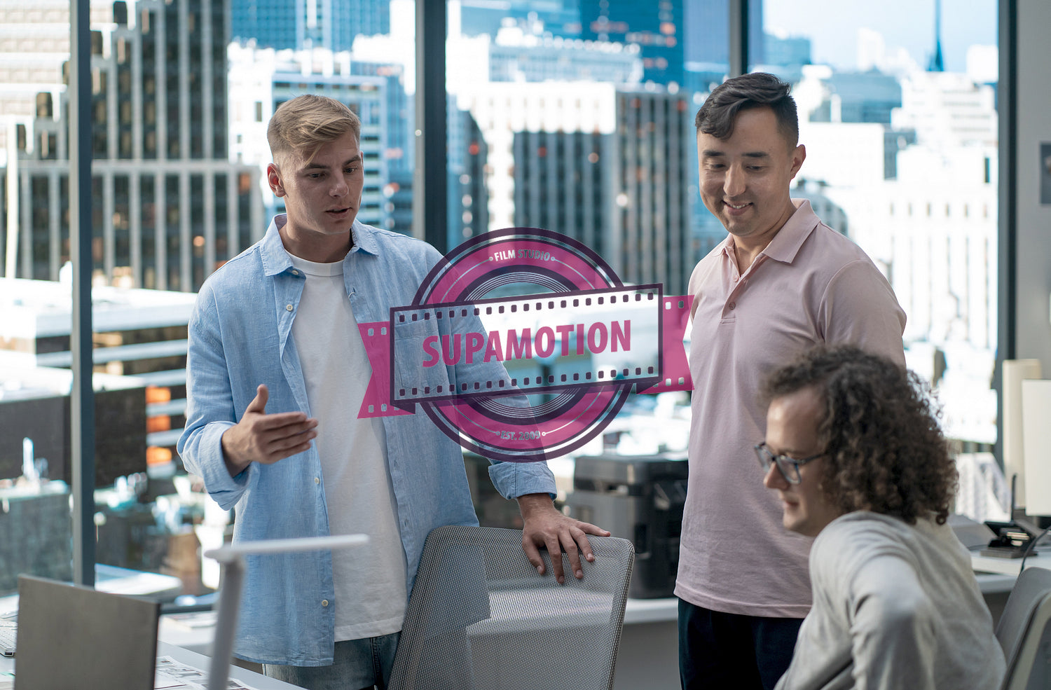 Diverse team of employees brainstorming, gathering around the computer screen