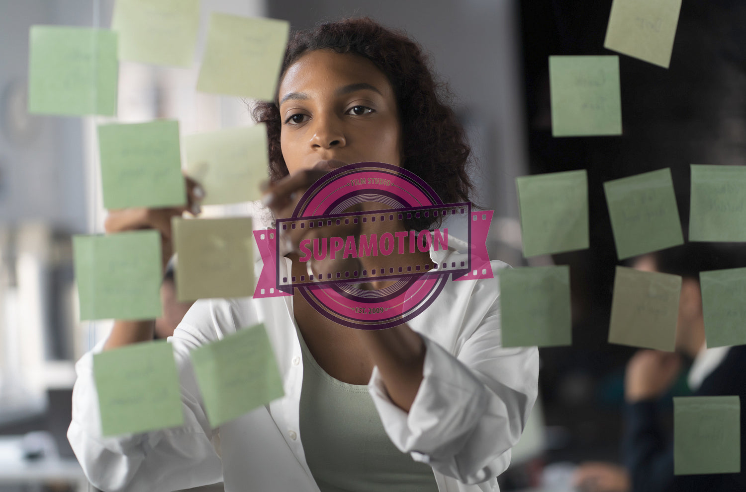 Young African American female employee looking at adhesive sticky notes