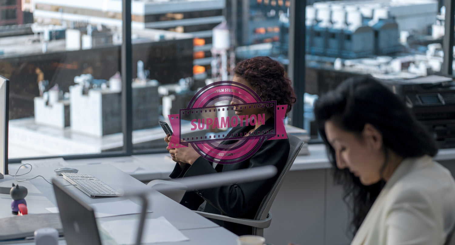 African American female employee using her smartphone at her desk