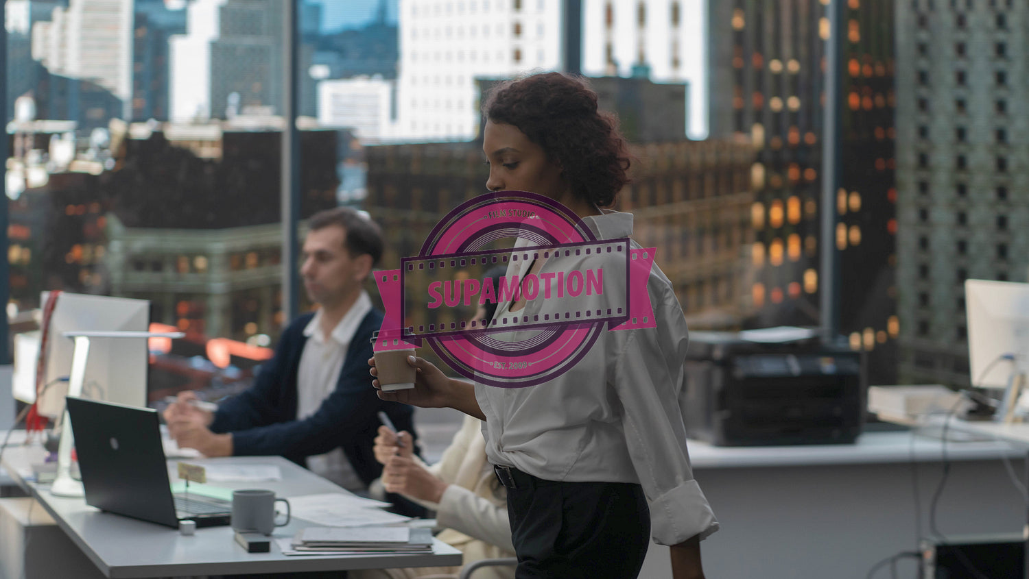 African American female walking with a morning coffee to her working desk