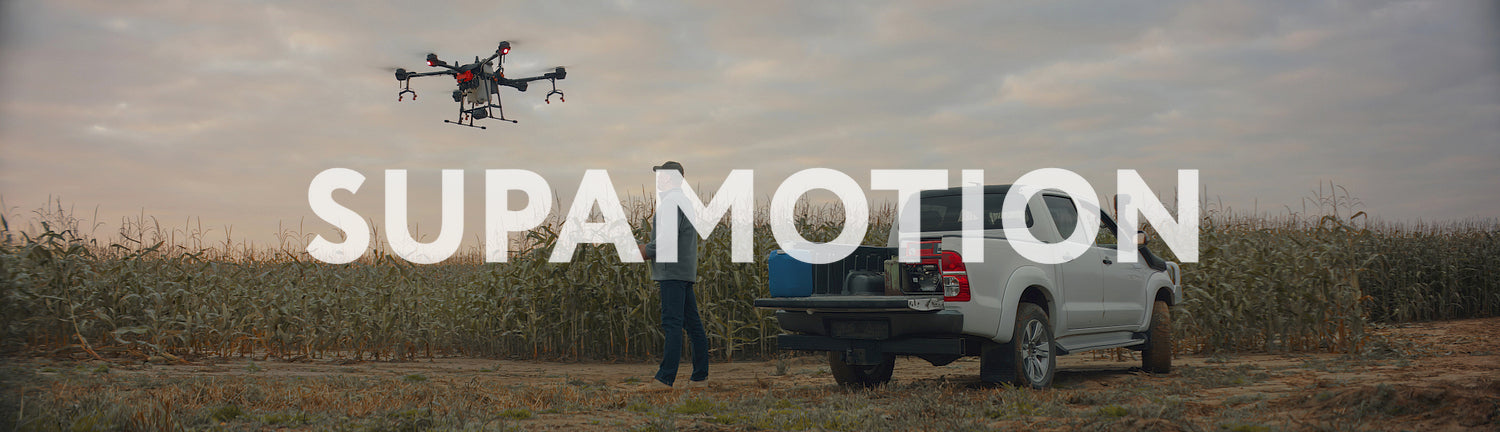 Huge intelligent agriculture drone with spray nozzles taking off near corn field