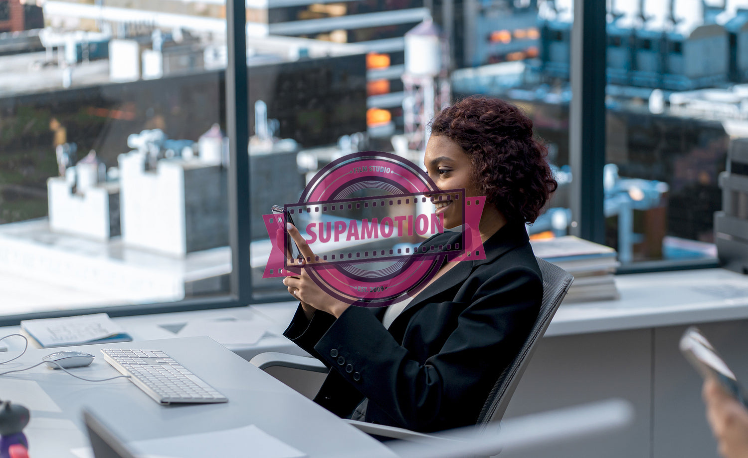 African American female employee using her smartphone at her desk