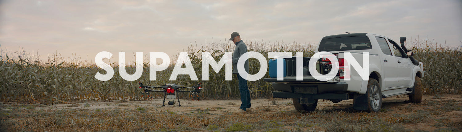 Huge intelligent agriculture drone with spray nozzles taking off near corn field