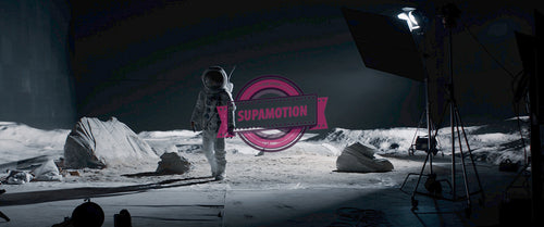 Actor in astronaut suit walking on the surface of a moon landing movie set