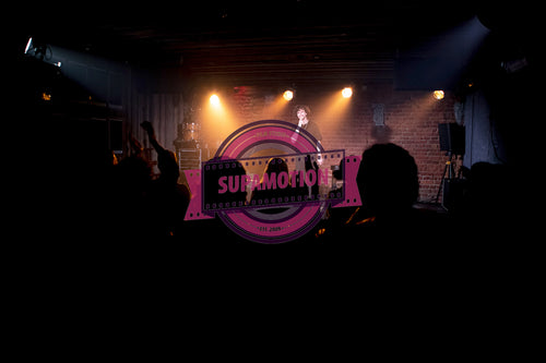 Young Caucasian male comedian performing his stand-up monologue on a stage of a small venue