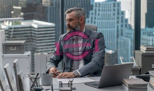 Portrait of 50s Caucasian businessman looking out of the window of his office